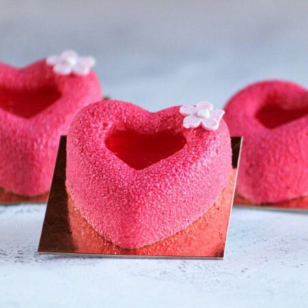 На фото муссовое пирожное Сердце производителя "Шарлотка", пирожное в виде сердца, розового цвета.