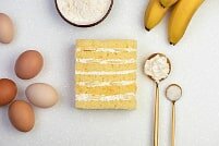На фото бананы, яйца, крем, бисквит, ингредиенты для бананового торта, производитель кондитерских изделий под заказ Шарлотка.