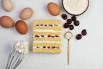 На фото вишни, яйца, крем, бисквит, ингредиенты для торта, производитель кондитерских изделий под заказ Шарлотка.