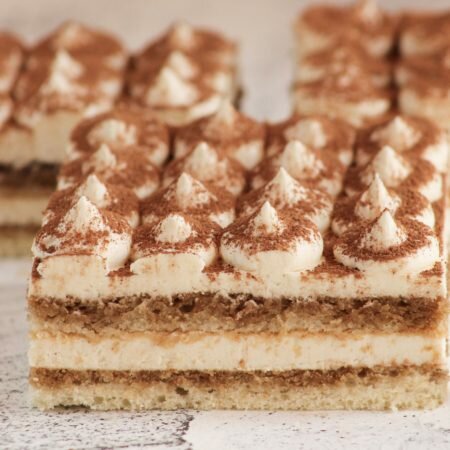 На фотографии торт Тирамису, производителя кондитерских изделий под заказ Шарлотка, белый бисквит с кофейной пропиткой.